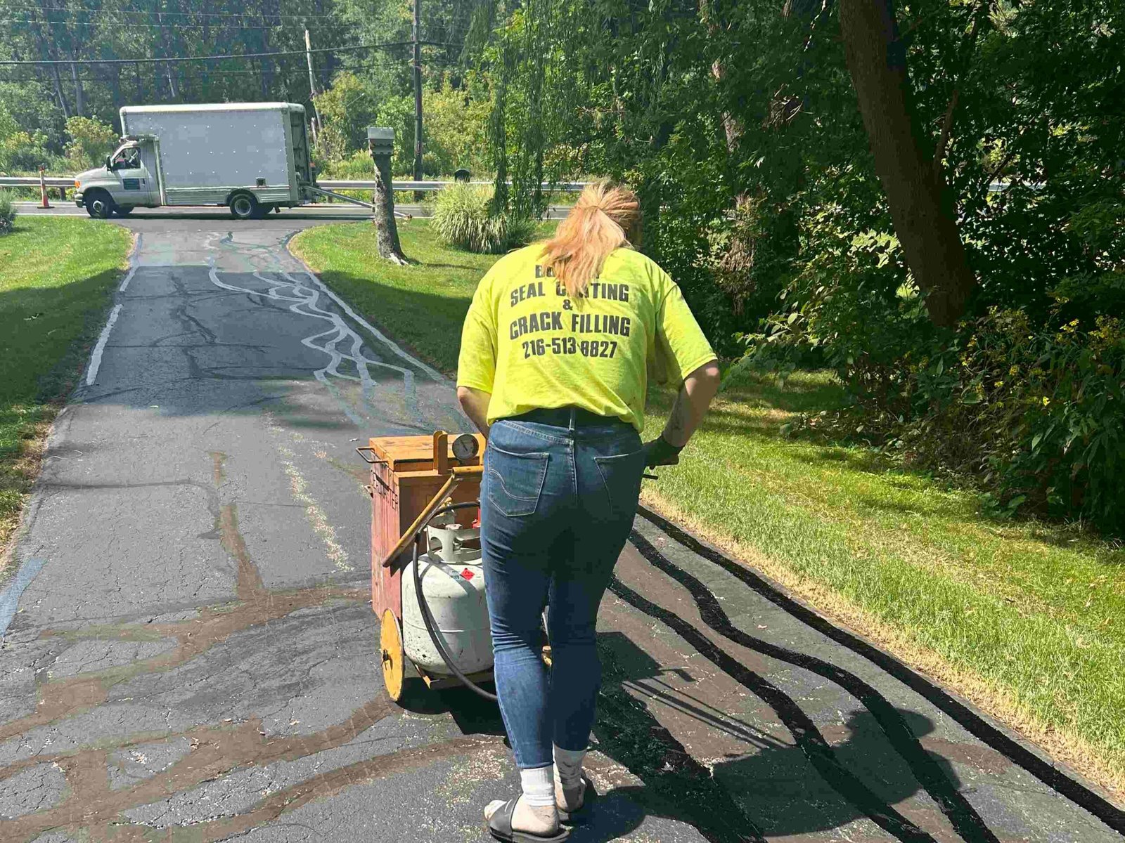 Crew laying fresh asphalt on a driveway