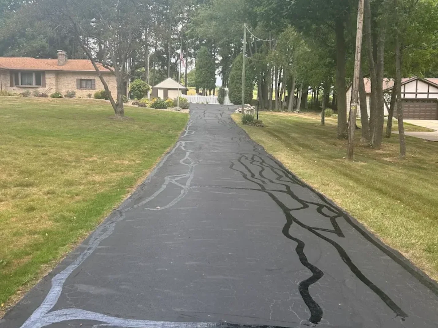 Crew filling cracks in an asphalt driveway